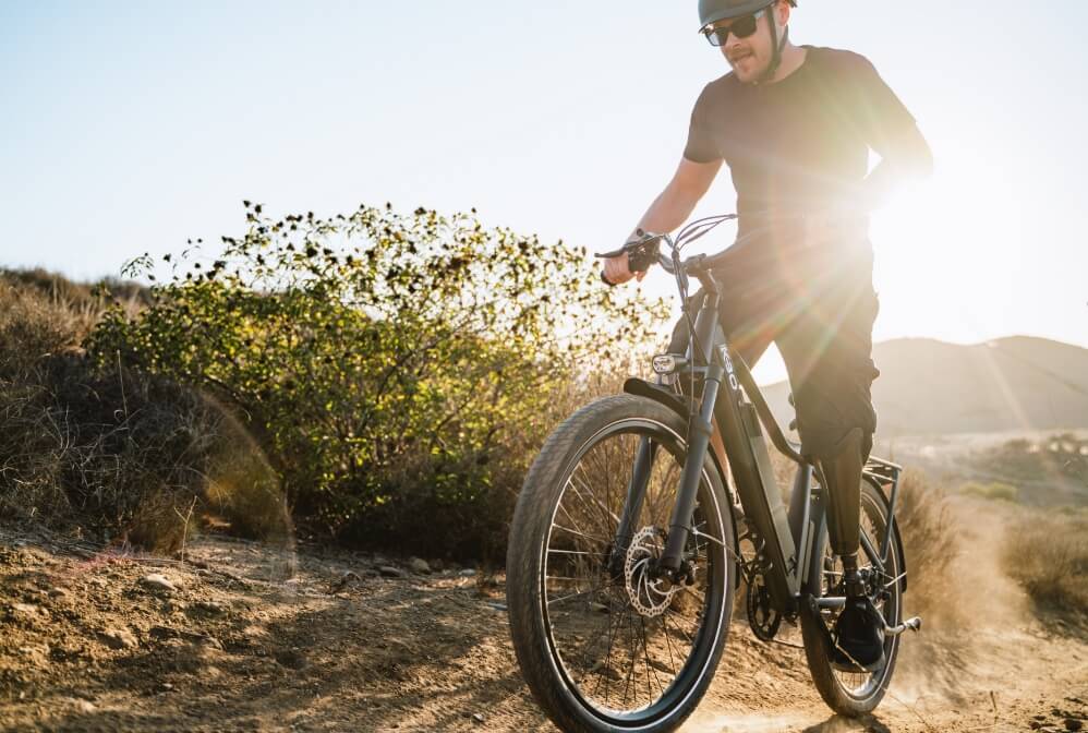 A person riding a mountain bike on a trail surrounded by rocky terrain.