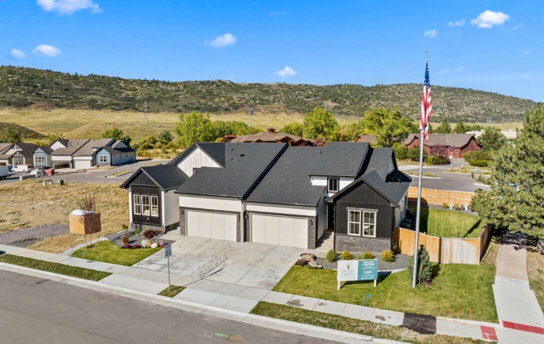 The Ponderosa and Willow villa model homes in Deer Creek, a new community in Denver, Colorado, featuring elegant brick and stone exteriors, well-maintained lawns and gardens.