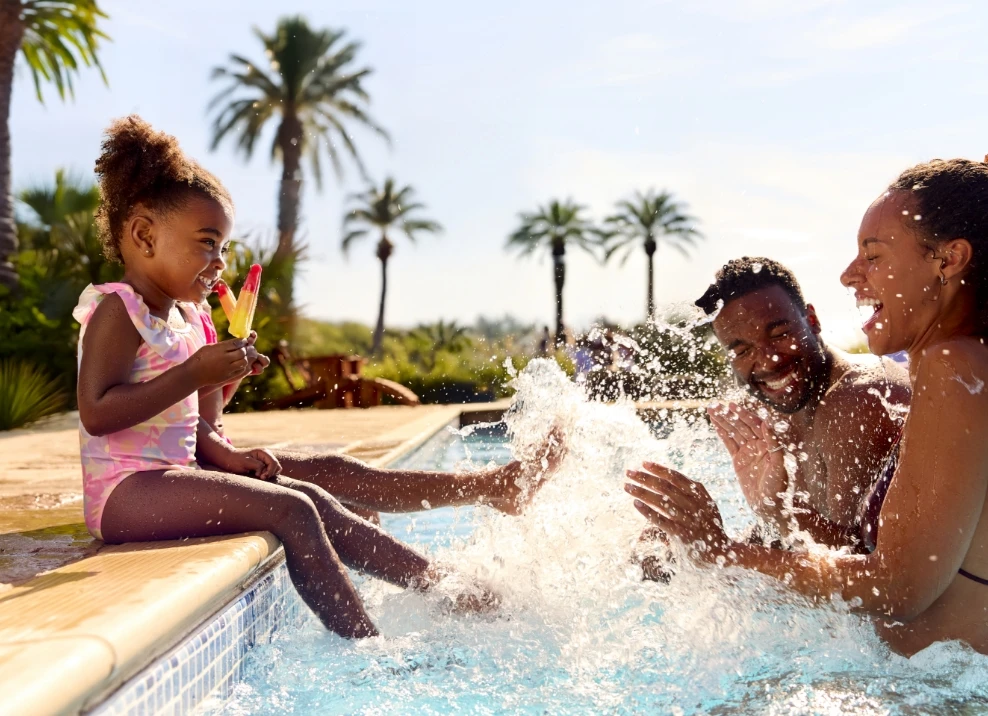 family splashing water in swimming pool