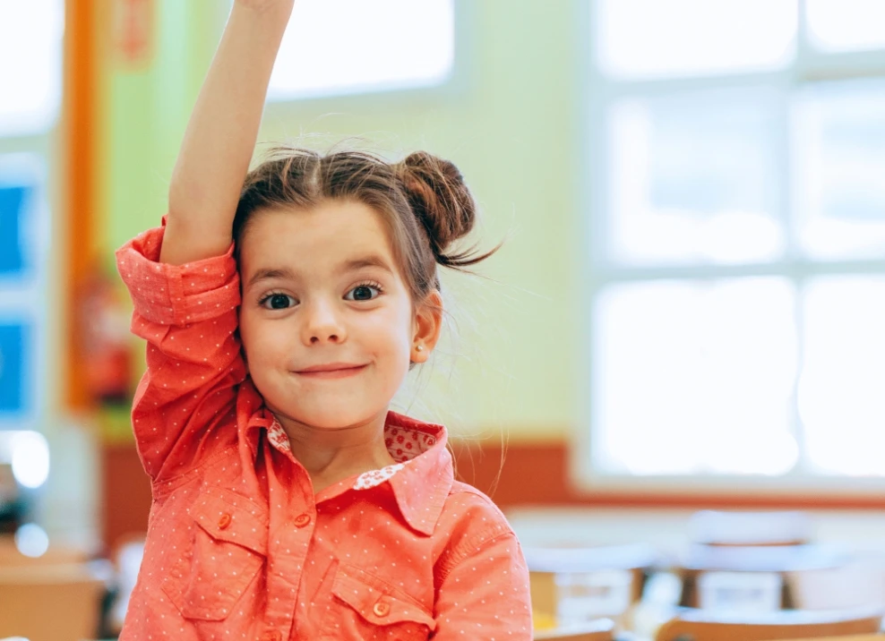 girl raising hand in classroom