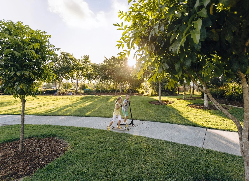 Kids riding scooters on park pathway